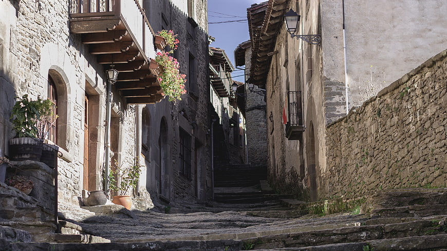Narrow cobblestone street in historic European village with stone buildings