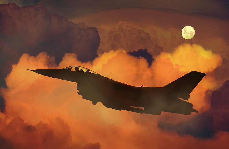 Fighter Jet Silhouette Flying Through Dramatic Sunset Clouds