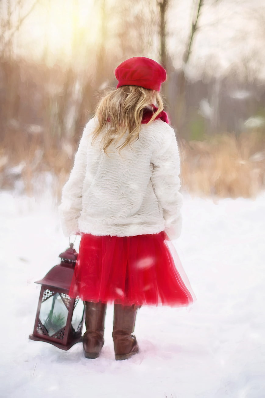 Woman in Red Skirt and White Coat Walking in Snow with Lantern
