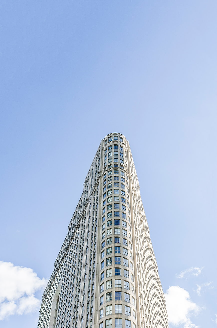 Low angle view of modern skyscraper against blue sky