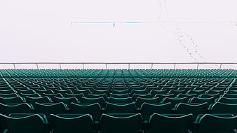 Rows of empty green stadium seats in winter snow