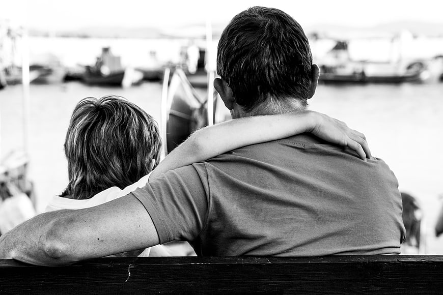 Father and Son Embrace at Harbor