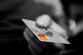 Hand holding Mastercard credit card in black and white
