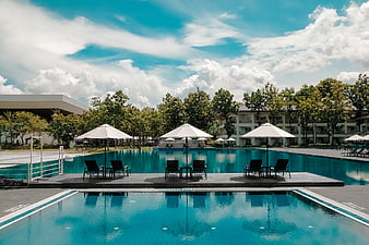 Luxury Resort Swimming Pool with Lounge Chairs and Blue Sky