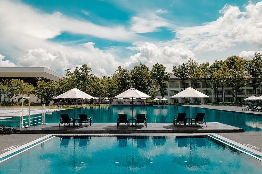 Luxury Resort Swimming Pool with Lounge Chairs and Blue Sky