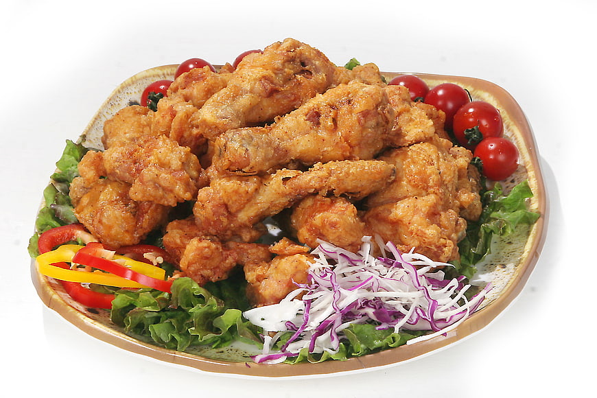 Crispy Fried Chicken Wings with Fresh Salad on White Background