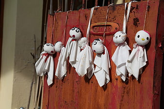 Handmade fabric dolls hanging on rustic red wooden door