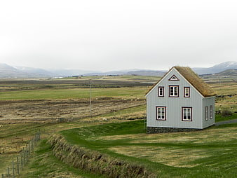 Traditional Icelandic turf house in green landscape
