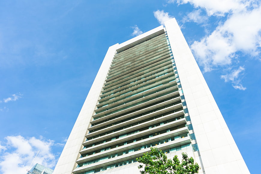 Low angle view of modern white skyscraper against blue sky