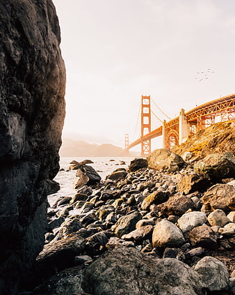 Golden Gate Bridge View from Rocky Shoreline at Sunset