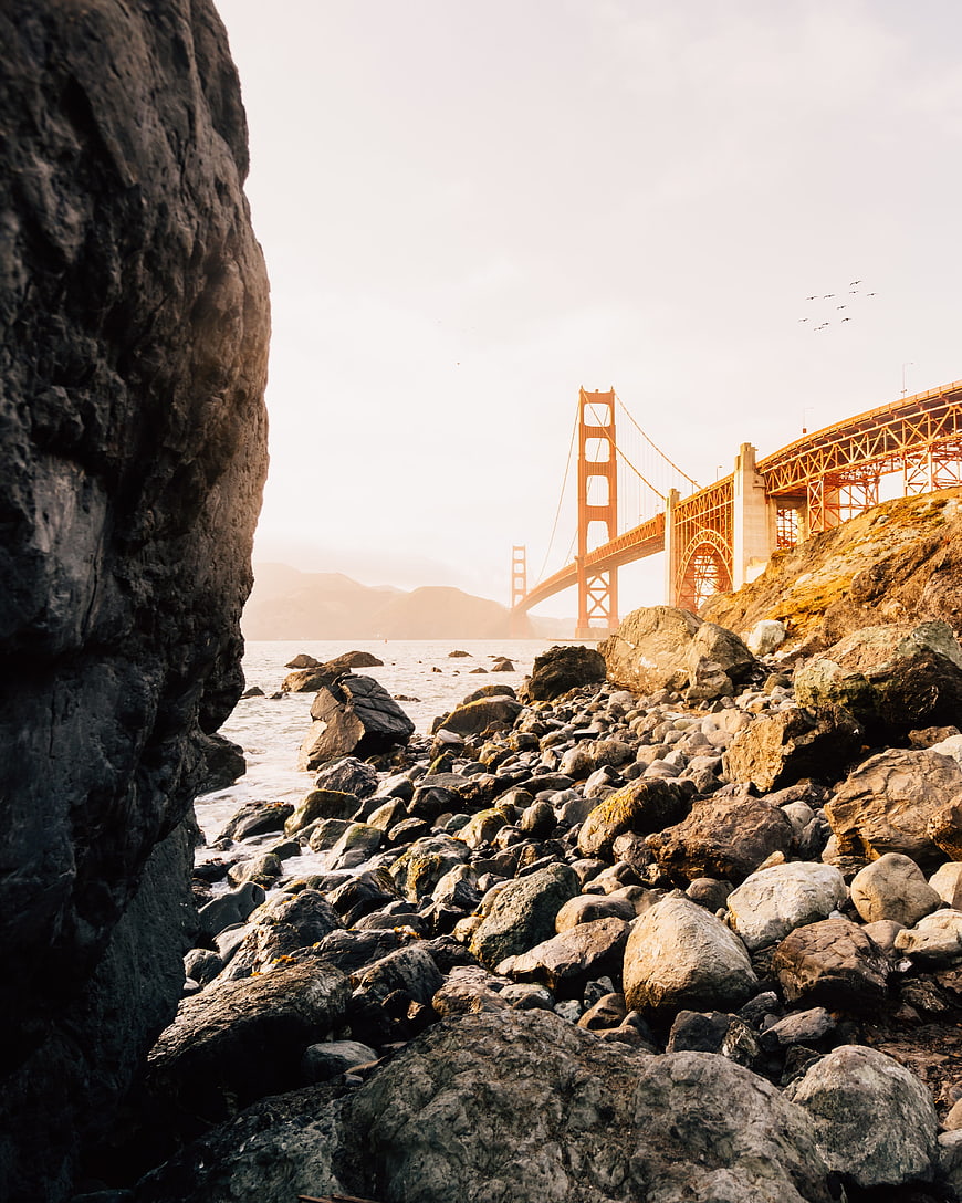 Golden Gate Bridge View from Rocky Shoreline at Sunset