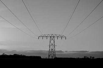 Silhouette of High Voltage Power Tower Against Gray Sky