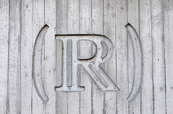 Engraved Letter R on Textured Concrete Wall