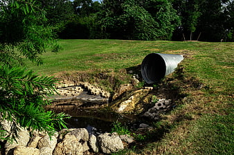 Corrugated metal pipe discharging into eroded stream bank