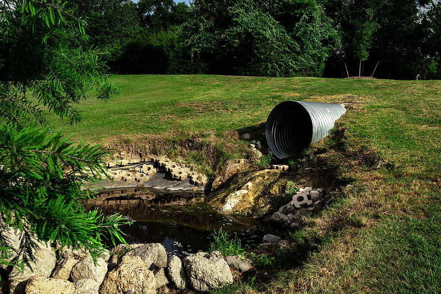 Corrugated metal pipe discharging into eroded stream bank