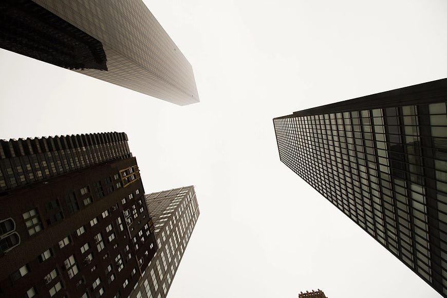 Low angle view of skyscrapers against white sky