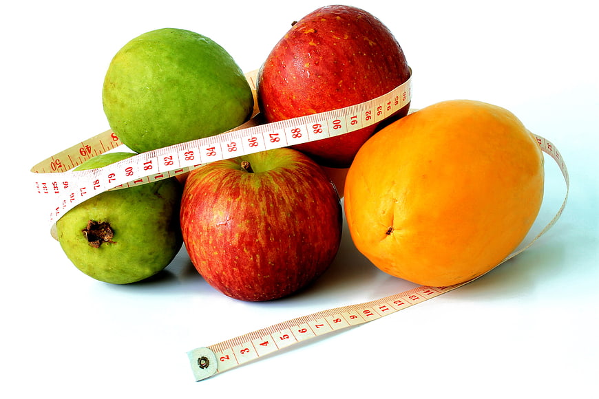 Fresh fruits with measuring tape for healthy diet concept