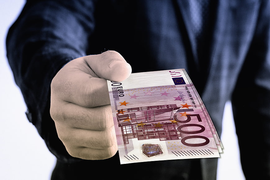 Hand Holding 500 Euro Banknotes in Business Suit