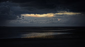 Dramatic Stormy Sunset Over Dark Ocean Beach With Birds