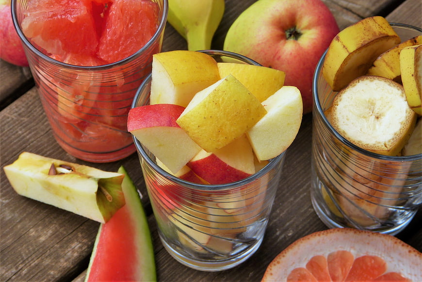 Fresh fruit salad in glasses on wooden table