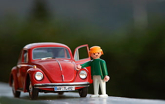 Red toy Volkswagen Beetle with Playmobil figure
