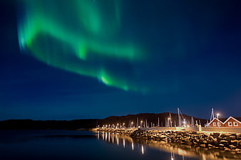 Aurora Borealis Over Norwegian Harbor With Red Boathouse