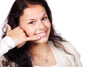 Smiling woman making call me gesture on white background