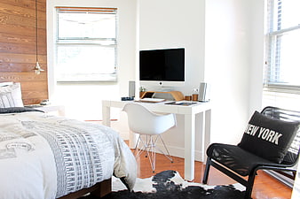 Modern minimalist bedroom with workspace and wood accent wall
