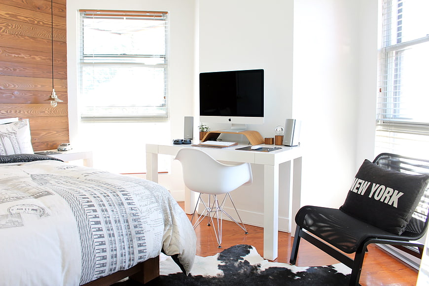 Modern minimalist bedroom with workspace and wood accent wall