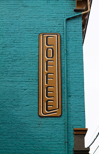 Vertical Coffee Sign on Teal Brick Wall