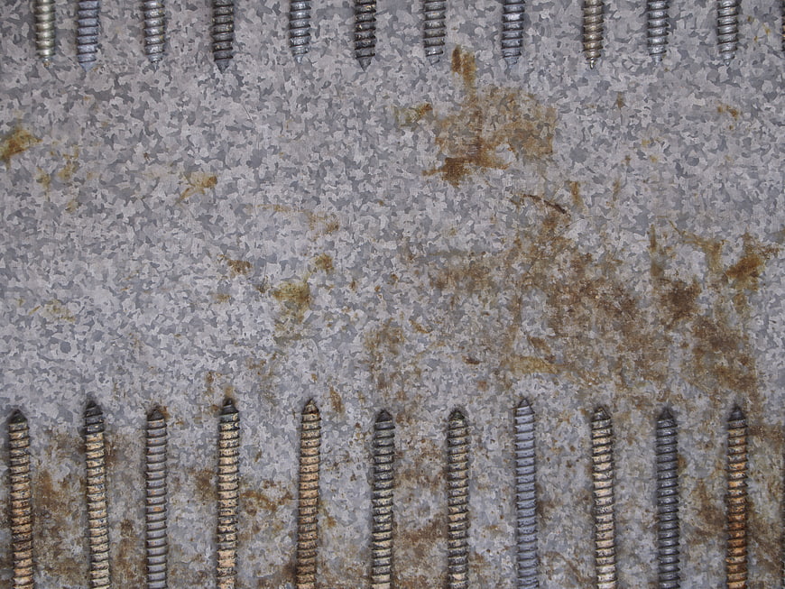 Rusted metal plate with screws texture background