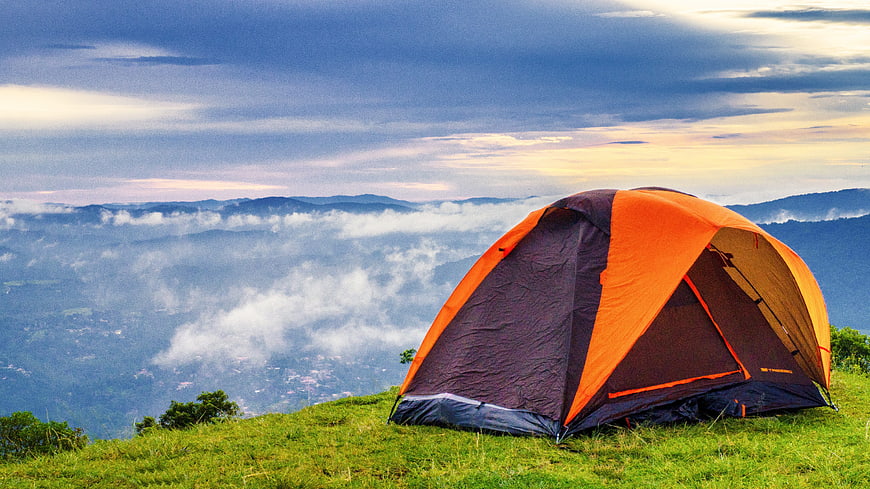 Orange Tent On Mountain Ridge Above Sea Of Clouds