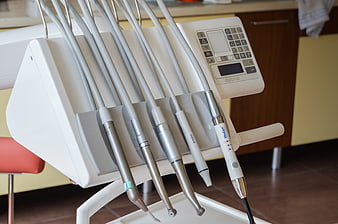 Close-up of dental handpieces and control panel in clinic