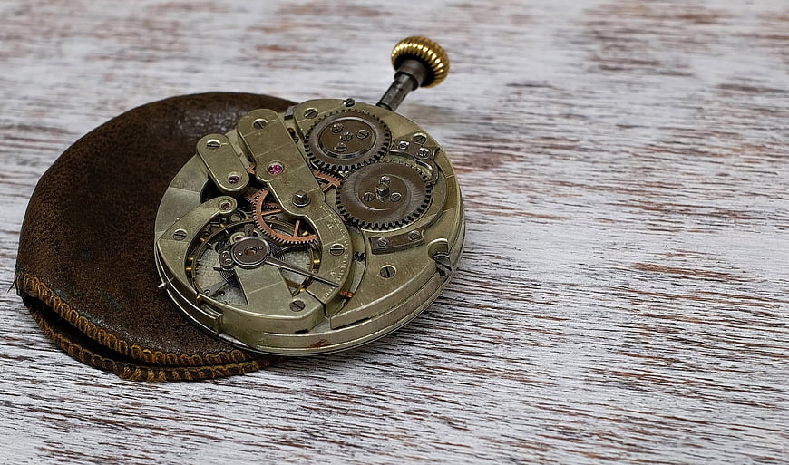 Vintage Pocket Watch Mechanism on Wooden Background