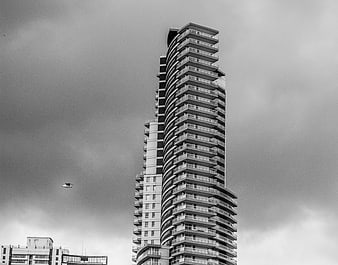Modern Curved Skyscraper Against Cloudy Sky