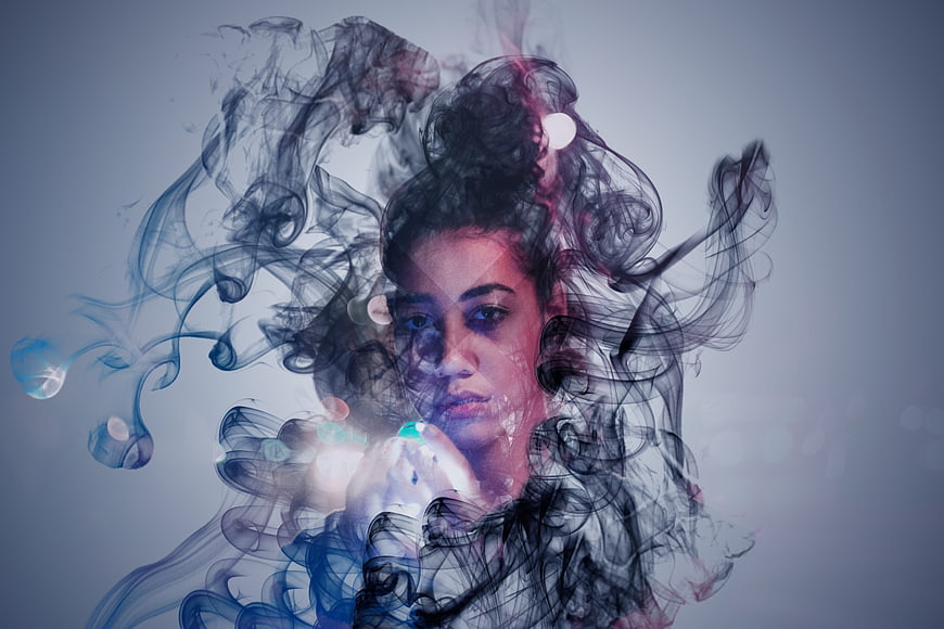 Artistic double exposure portrait of woman with smoke
