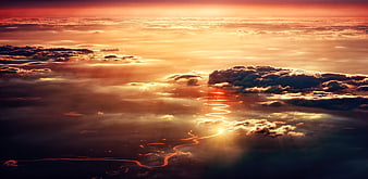Aerial View of Winding River Through Clouds at Sunset