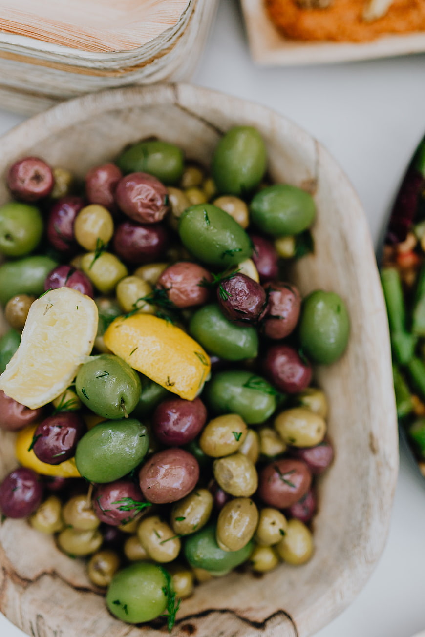 Wooden Bowl of Mixed Olives with Lemon and Herbs
