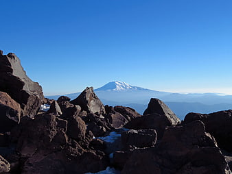 Snow-capped mountain peak viewed through rocky foreground