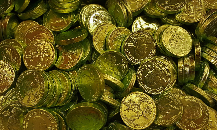 Pile of shiny gold coins with green lighting