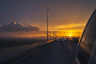 Sunset Highway Traffic with Golden Sky and Clouds