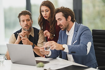 Business team discussing work on laptop in office