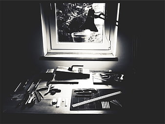 Black and white workshop desk with tools and window light