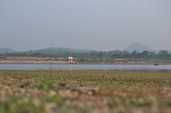 Serene Lake Landscape with Distant Mountains and Foreground Vegetation