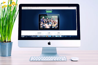 iMac computer with Facebook website on desk with daffodils