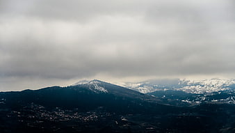 Dramatic Snow-Capped Mountain Landscape Under Cloudy Sky