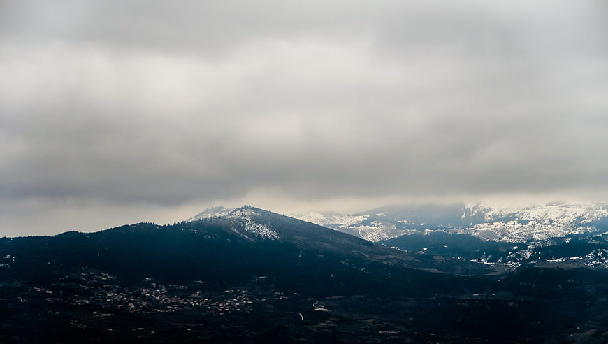 Dramatic Snow-Capped Mountain Landscape Under Cloudy Sky