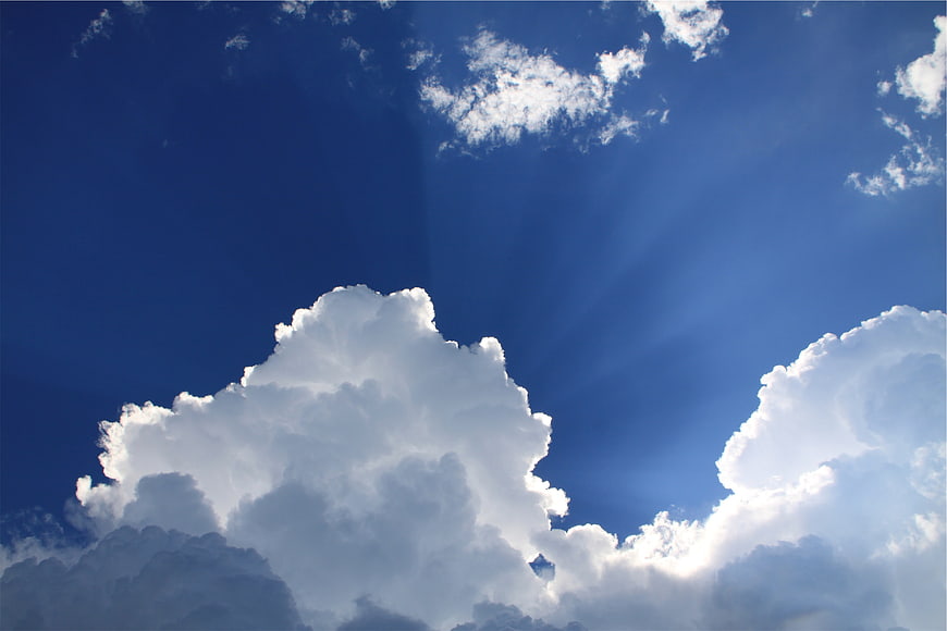 Dramatic Blue Sky with Sunbeams and Fluffy White Clouds