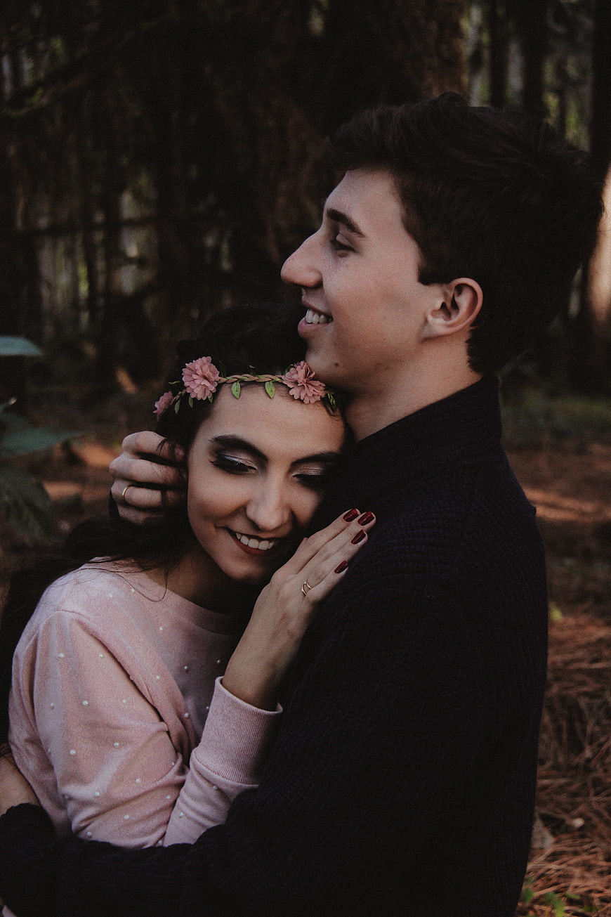 Happy couple hugging in forest with flower crown