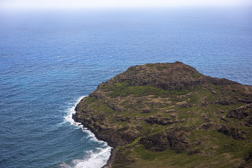 Aerial view of rugged volcanic coastline with blue ocean waves